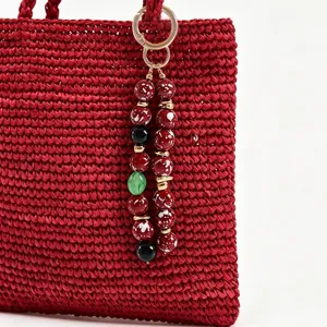 Sac en crochet rouge fait main avec pendentif porte-clés en perles acryliques colorées.