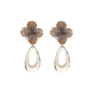 Detail view of fashion floral fabric acrylic teardrop earrings with golden metal base.