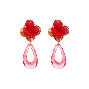 Close-up of red fabric flower and pink acrylic teardrop dangle earrings detail shot.