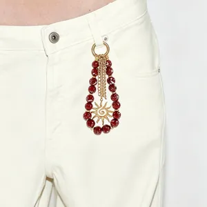 Breloque pendentif soleil en perles acryliques rouges pour sacs ou pantalons. Détail.