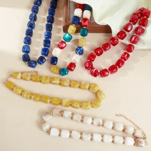Close-up detail of colorful acrylic chunky beaded necklaces featuring vibrant resin stones.