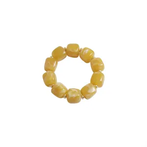 Yellow acrylic block bead bracelet detail, stylish resin geometric jewelry for women daily wear.