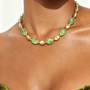 Primo piano dettagliato di una collana vintage elegante con perle dorate e verdi.
