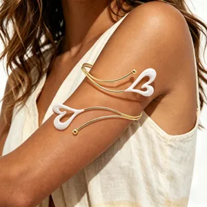 Elegante goldfarbene Metall Oberarm Manschette Armband mit schickem weißen Herz Öltropfen Design.