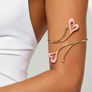 Goldener Metall-Armreif mit zwei rosa Emaille-Herzanhängern, offener verstellbarer Armschmuck.