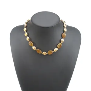 Elegante collana corta vintage con perle in resina ambra irregolari e sfere di metallo dorato