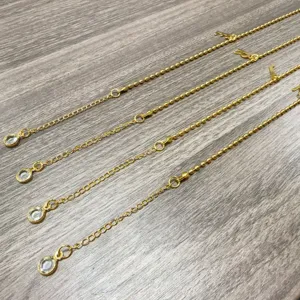 Gedetailleerd overzicht van gouden ketting sieraden met kristallen hanger en letters, fijn.