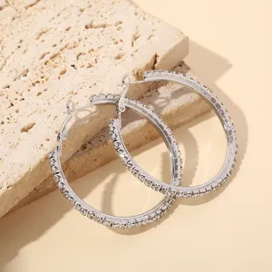 Close-up opname van sprankelende strass C-vormige oorbellen, elegant en stralend detail.