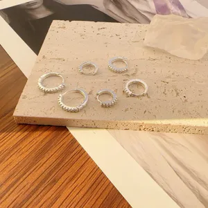 Detailopname van kristalen hoepeloorringen set, elegante sieradenweergave op steen.