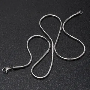 Close-up detail van zilveren titanium staal ronde slang ketting halsketting sieraad.