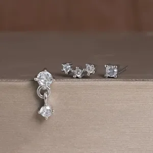 Detailopname van een minimalistische koperen oorbellen set met strass, heel elegant.