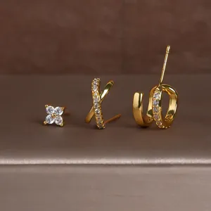 Gedetailleerd overzicht van de gouden driedelige oorbellen set met klaver en kruis.