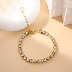 Gedetailleerd shot van gouden tennisarmband met fonkelende heldere strass-steentjes voor stijl.