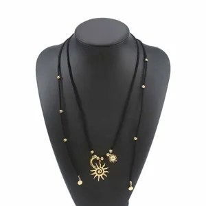 Largo collar de cordón de terciopelo bohemio con colgantes dorados de sol y luna.