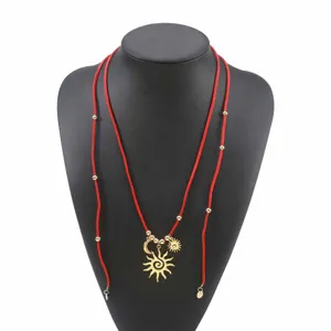 Largo collar bohemio de terciopelo rojo con colgantes de sol y luna dorados, estilo vacacional.