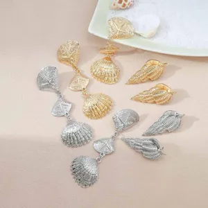 Detail shot of summer beach ocean style shell and conch earrings, metal fashion jewelry.