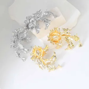 Close up detail of irregular abstract molten metal earrings in silver and gold color options.