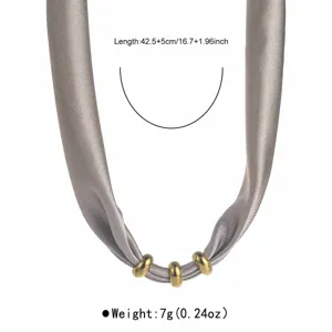 Detail view of grey fabric necklace with gold rings, showing precise length and light weight.