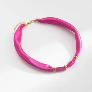 Detailed close-up of hot pink satin fabric choker necklace with chic gold stainless steel rings.