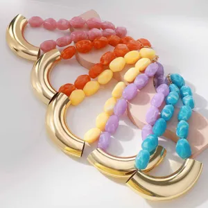 Detailed close-up of colorful resin bead necklaces with metallic gold curved tube accents.