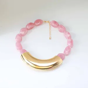 Close-up of pink marbled resin bead statement necklace with large curved metal element.