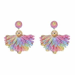 Primo piano di orecchini pendenti in rafia colorata fatta a mano, stile vacanza estiva.