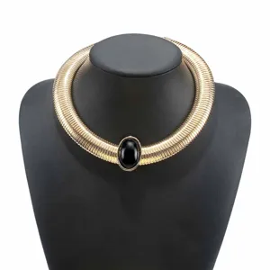Gold chunky ribbed metal choker necklace with a central black oval stone detail.