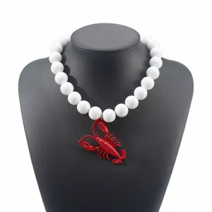 Collana di perle bianche con ciondolo aragosta rossa per vacanze estive e stile moda chic.