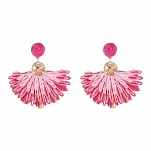 Vista ravvicinata di orecchini a ventaglio in rafia intrecciata, rosa con dettagli oro.