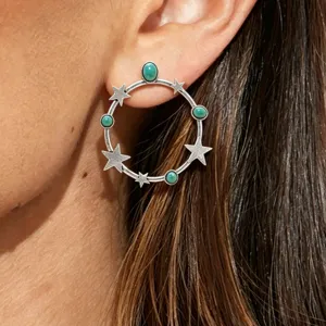 Detailed close-up view of vintage silver star hoop earrings featuring natural turquoise stones.
