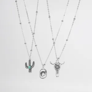Western cowboy style silver necklace set with vintage bull skull and cactus turquoise pendants.