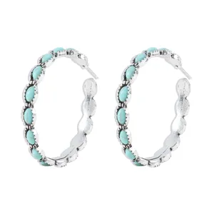 Detailed close-up of retro turquoise hoop earrings, silver-plated vintage western jewelry.