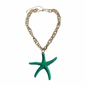 Detail view of the green resin starfish pendant on chunky gold chain, beach vacation style.