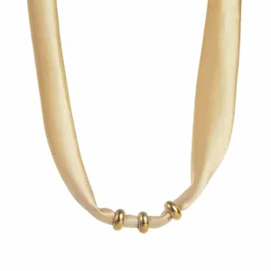 Close-up of the golden fabric silk scarf necklace showing metallic ring details and texture.