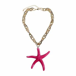 Close-up detail of the fashion summer beach style pink resin starfish pendant gold chain necklace.