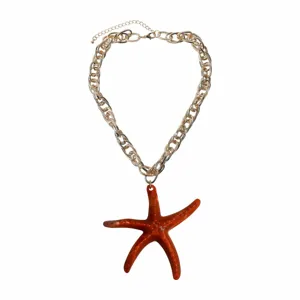 Detailed view of the resin starfish pendant on a gold chain, ocean vacation style jewelry.