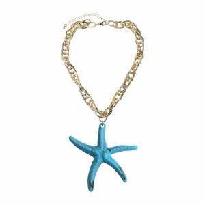 Close-up detail of the colorful resin starfish pendant necklace with chunky gold chain.