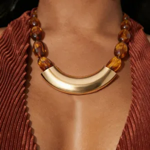 Retro geometric resin handmade beaded necklace with bold gold curved metal pendant main view.