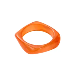 Bracelet en résine irrégulier orange gros plan, détail de bijoux de mode géométrique chic.