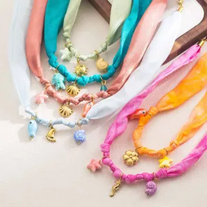 Vue détaillée de colliers en ruban de tissu coloré avec de charmants pendentifs marins dorés.