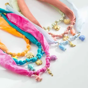 Gros plan détaillé de colliers en ruban de tissu coloré avec de charmants pendentifs marins.