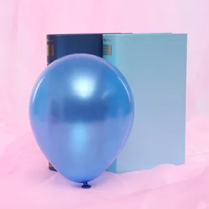 Close-up of a glossy metallic blue balloon in front of decorative books for party details.