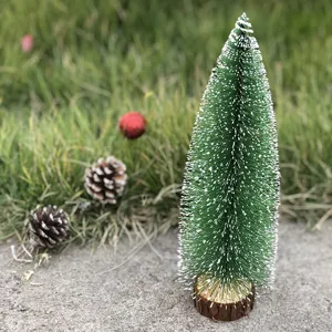 Mini snow-flocked Christmas tree detail, desktop seasonal ornament decor, green tabletop prop.