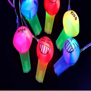 Detailed view of glowing light-up party whistles with fun facial expressions and lanyards.