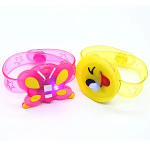 Close-up view of glowing cartoon wristbands featuring cute butterfly and winking emoji designs.