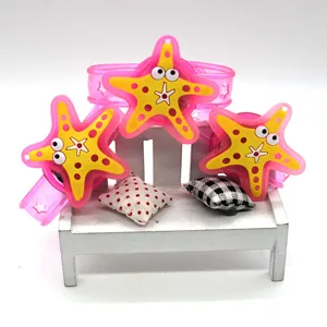 Close-up detail shot of luminous starfish silicone wristbands displayed on a mini chair.