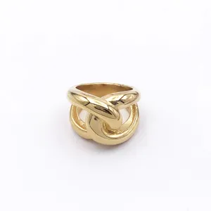 Gedetailleerd overzicht van de brede gouden in elkaar grijpende ring met prachtig.