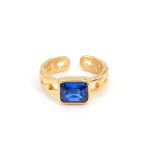 Goldener Titanstahl Offener Ring mit funkelndem rechteckigen blauen Zirkon und Kettenstruktur.