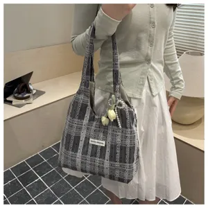 Detail view of the Korean style plaid tote bag, featuring a small label and cute pearl tulip pendant decoration.
