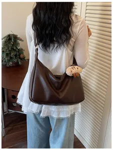 Λεπτομερής εικόνα από καφέ casual vintage τσάντας ώμου με χαριτωμένο λούτρινο αξεσουάρ.
